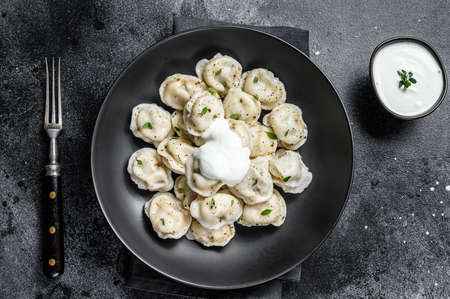 Homemade ravioli dumplings with beef and pork meat. Black background. top viewの写真素材