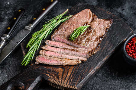 Grilled veal meat chop steak on a cutting board. Black background. Top viewの写真素材