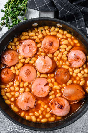 Beans with sausages in tomato sauce in a pan. White background. Top viewの写真素材