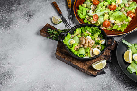 Set of salads with avocado, prawns, shrimps and greens in bowls. White background. top view. Copy spaceの写真素材