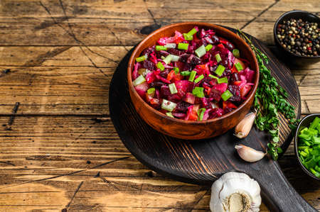 Traditional russian salad vinaigrette with boiled vegetables, pickled cucumbers in bowl . Wooden background. Top view. Copy spaceの写真素材