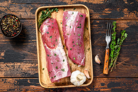 Marinated pork tenderloin meat steak with thyme. Dark wooden background. Top viewの写真素材