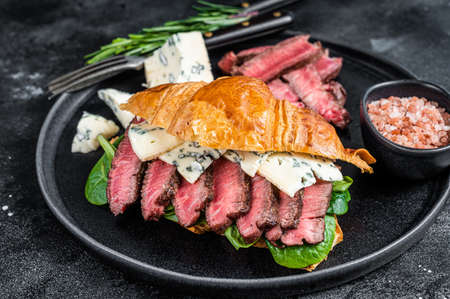 Croissant Sandwich with Fillet Mignon tenderloin meat steak with blue cheese. Black background. Top viewの写真素材