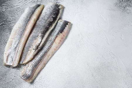 Pickled marinated sea herring fillet. White background. Top view. Copy space