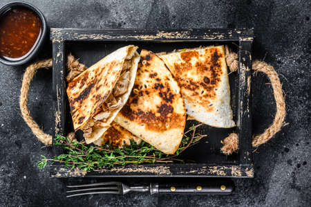 Mexican quesadilla with chicken, tomato, corn and cheese. Black background. Top view.の写真素材