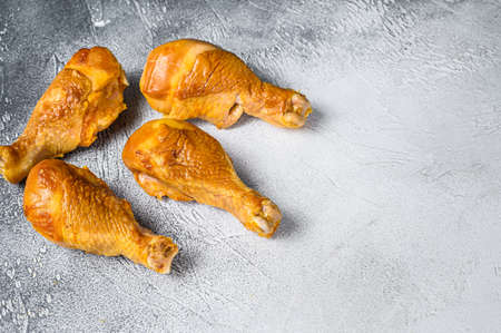 Smoked chicken leg drumsticks on a kitchen table. White background. Top view. Copy space