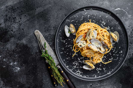 Seafood Spaghetti pasta with Clams vongole in a plate. Black background. Top view. Copy spaceの写真素材