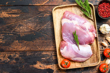 Raw fillet of farm Turkey thigh. Dark wooden background. Top view. Copy spaceの写真素材