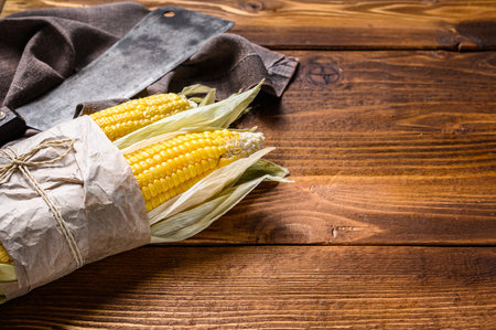 Fresh corn on cobs on rustic wooden table. Dark background. Top view. Copy spaceの写真素材