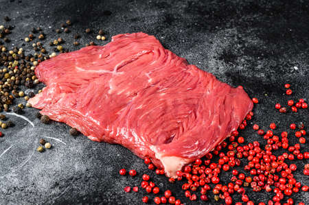 Raw outside skirt steak with black and pink pepper. Black background. Top viewの写真素材