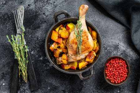 Roasted duck legs with oranges, peach and spices. Black background. Top viewの写真素材