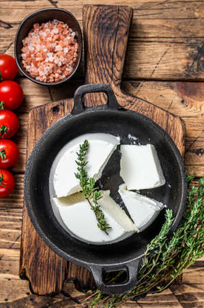 Fresh Ricotta cream Cheese in a pan with basil and tomato. wooden background. Top viewの写真素材