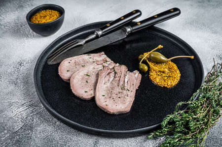 Veal or beef boiled tongue slices on a plate. White background. Top viewの写真素材
