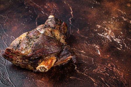 Roast Lamb leg with herbs and garlic. Dark background. Top view. Copy spaceの写真素材