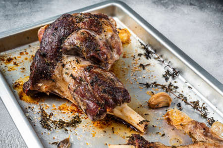 Roasted lamb mutton whole leg in a baking dish. White background. Top viewの写真素材