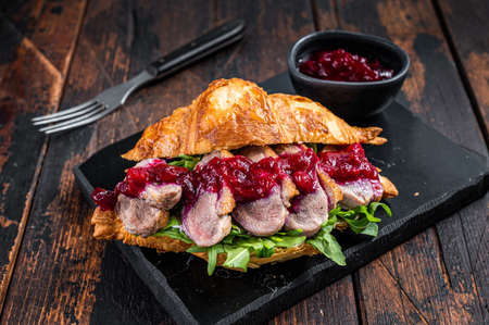 Sandwich with Duck breast fillet steak slices, arugula and sauce. Dark wooden background. Top Viewの写真素材