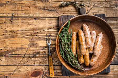 Fried Chorizo and Bratwurst sausages in a wooden plate. wooden background. Top View. Copy spaceの写真素材