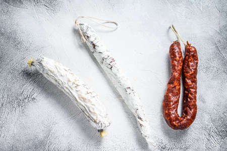 Spanish salami, fuet and chorizo sausages on a kitchen table. White background. Top viewの写真素材