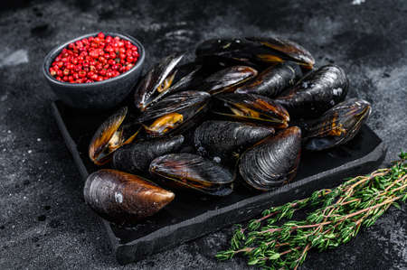 Boiled Mussels in shells on a marble board. Black background. Top viewの写真素材