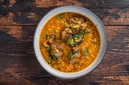 Kharcho beef meat soup with rice, tomatoes and spices in a bowl. Dark wooden background. Top viewの写真素材