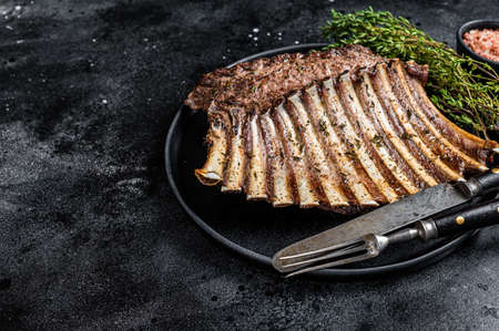 BBQ Grilled rack of Lamb mutton Ribs Chops on plate with thyme. Black background. Top view. Copy spaceの写真素材