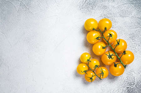 Small yellow cherry tomato on a kitchen table. White background. Top view. Copy spaceの写真素材