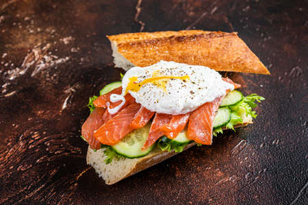 Poached egg with smoked salmon and avocado on toast. Dark background. Top viewの写真素材