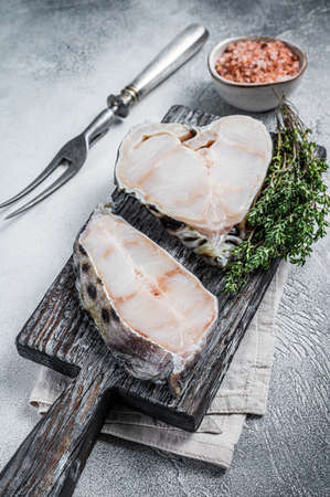 Raw wolf fish fillet fish Steak on wooden cutting board. White background. Top viewの写真素材