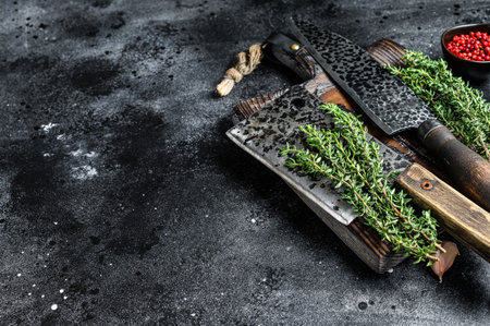 Chopping board and meat cleaver with knife. Black background. Top view. Copy spaceの写真素材
