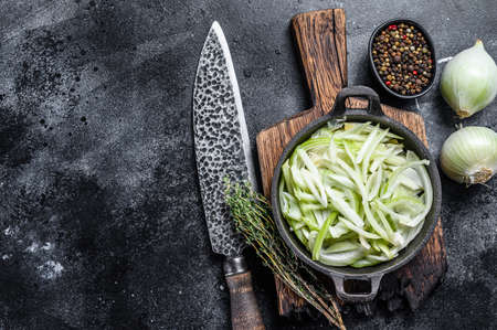 Sliced white onion in a pan. Black background. Top view. Copy spaceの写真素材