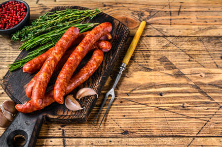 Pork Smoked sausages with addition of fresh aromatic herbs and spices. wooden background. Top view. Copy spaceの写真素材