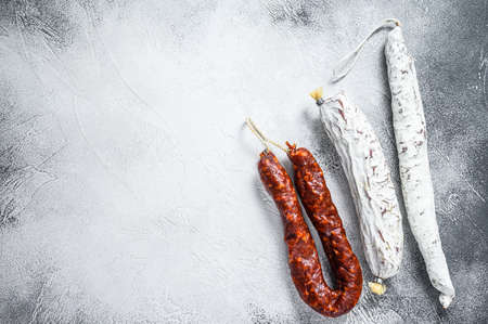 Spanish salami, fuet and chorizo sausages on a kitchen table. White background. Top view. Copy spaceの写真素材