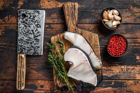 Blue Shark raw fish steaks on a cutting board with cleaver. Dark wooden background. Top viewの写真素材