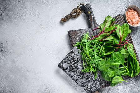 Fresh mixed greens, spinach, swiss chard and arugula. White background. Top view. Copy space