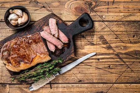 Sliced Grilled new york strip beef meat steak or striploin on a wooden board. background. Top view. Copy spaceの写真素材
