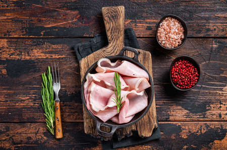 Prosciutto ham sliced in a pan. Dark wooden background. Top viewの写真素材