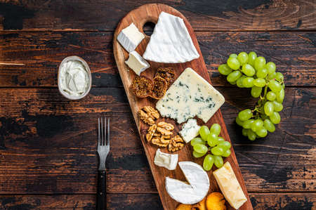 Assorted Cheese board with Brie, Camembert, Roquefort, parmesan, blue cream cheese, grape and nuts....