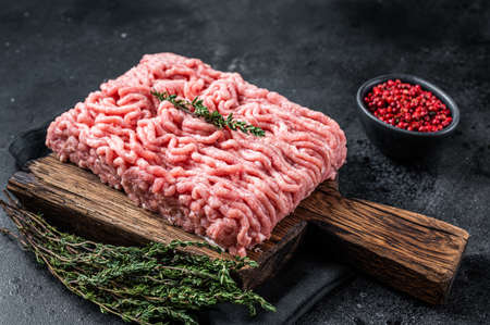 Ground chicken or turkey raw meat on wooden board. Black background. Top Viewの写真素材