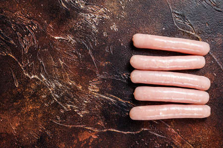 Raw chicken and turkey meat sausages on butcher table. Dark background. Top view. Copy spaceの写真素材