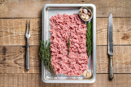 Turkey or chicken mince raw meat in a kitchen tray. Wooden background. Top Viewの写真素材