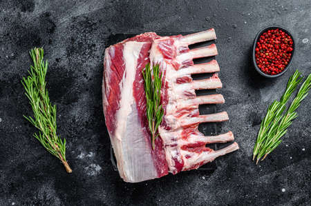 Raw fresh rack of lamb meat on marble board. Black background. Top viewの写真素材