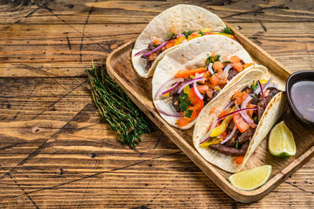 Tacos with beef meat, onion, tomato, sweet pepper and salsa. Mexican food. wooden background. Top view. Copy spaceの写真素材
