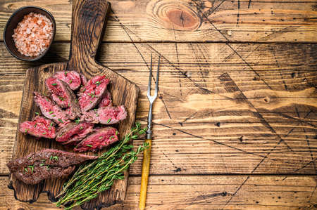 Sliced grilled machete skirt meat beef steak on a wooden cutting board. wooden background. Top view. Copy spaceの写真素材