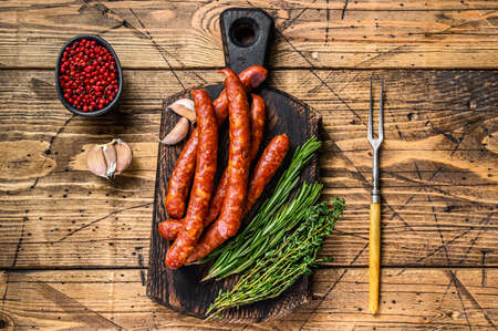 Pork Smoked sausages with addition of fresh aromatic herbs and spices. wooden background. Top viewの写真素材