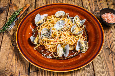 Italian seafood Spaghetti pasta with clams in a rustic plate. Wooden background. Top viewの写真素材