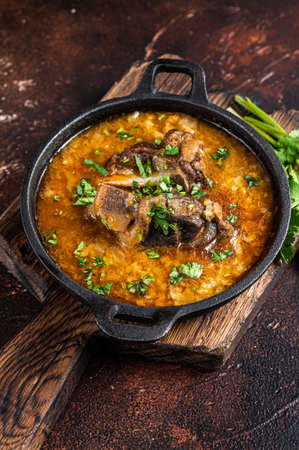 Kharcho soup with lamb meat, rice, tomatoes, carrots, peppers, walnuts and spices. Dark background....