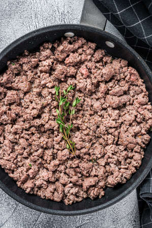 Fried mince beef and lamb meat in a pan with herbs. White background. Top viewの写真素材