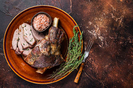 BBQ Roast Lamb mutton leg sliced on a rustic plate. Dark background. Top view. Copy spaceの写真素材