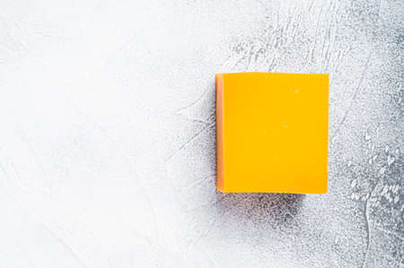 Cheddar Cheese block on a kitchen table. White background. Top view. Copy spaceの写真素材