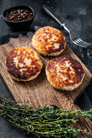 Homemade pork and beef cutlets or meatballs on wooden board. Black background. Top viewの写真素材